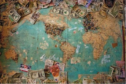 landkarte mit verschiedenen Geldscheinen und ländermarkierungen durch nadeln