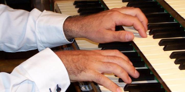 Ein Mann spielt auf einer Orgel.