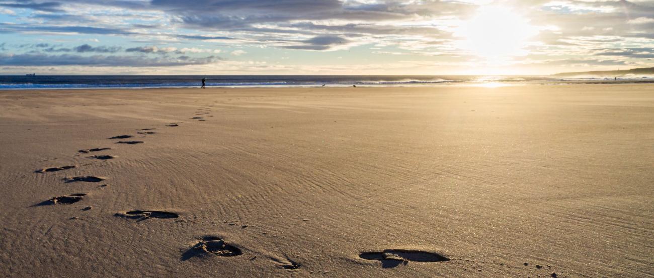 Sonnenuntergang Fußspuren im Sand