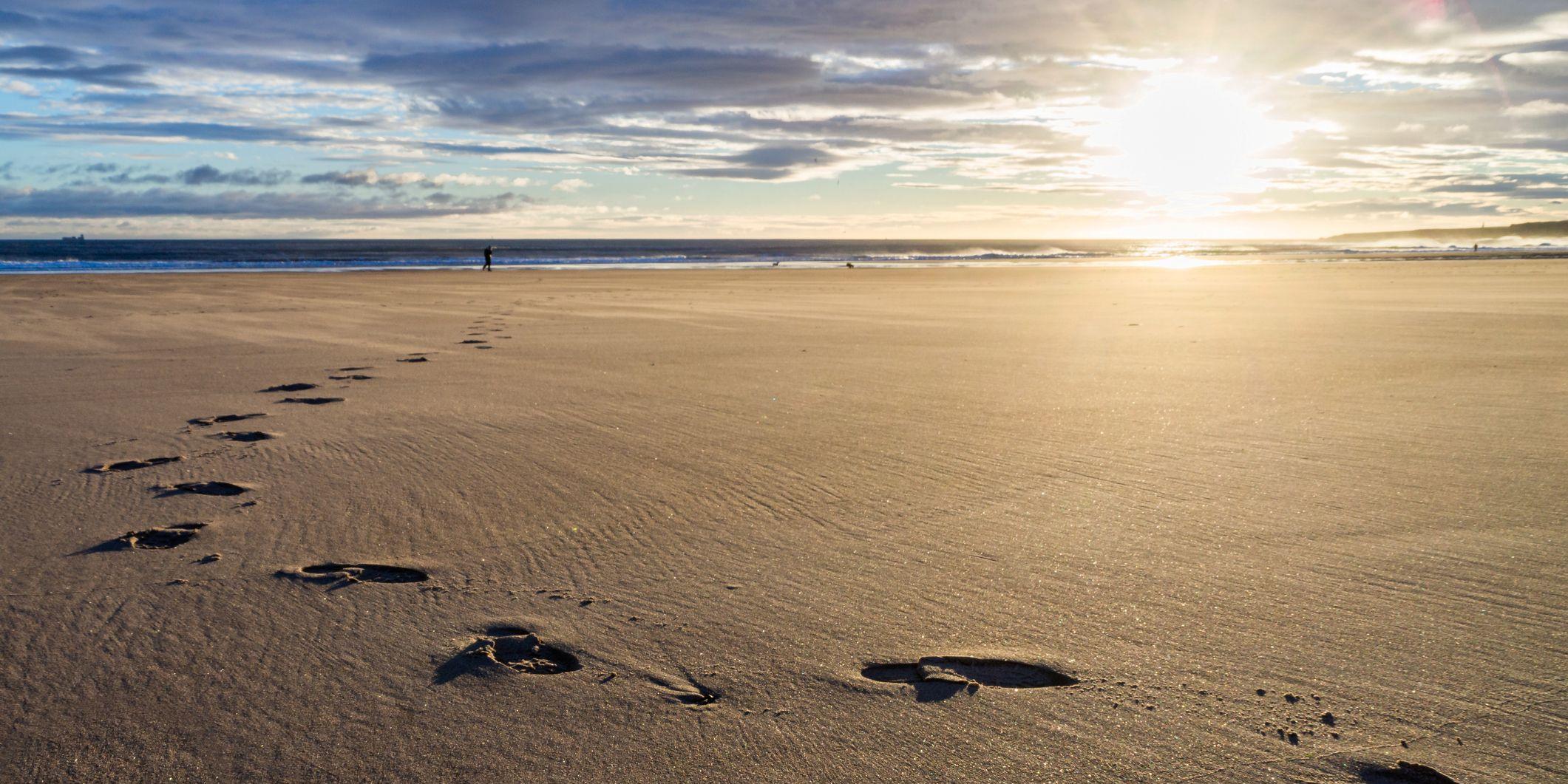 Sonnenuntergang Fußspuren im Sand
